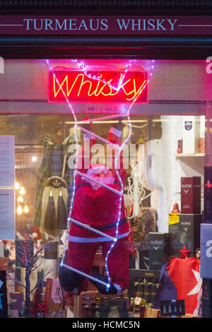 Turmeaus Whisky Shop, signs, and shoppers in the retail sector of the City of Chester, Cheshire, UK Stock Photo
