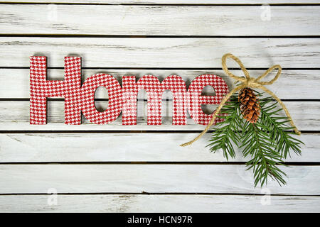 word Home in red and white gingham with pine and twine bow on whitewashed wood Stock Photo