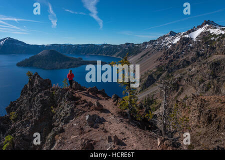 Tourist admiring Crater Lake as seen from Merriam Point with wizard island The Watchman and Hillman Peak Stock Photo