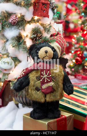 Christmas teddy bear displayed in front of tree and decorations Stock Photo