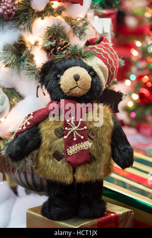 Christmas teddy bear displayed in front of tree and decorations Stock Photo