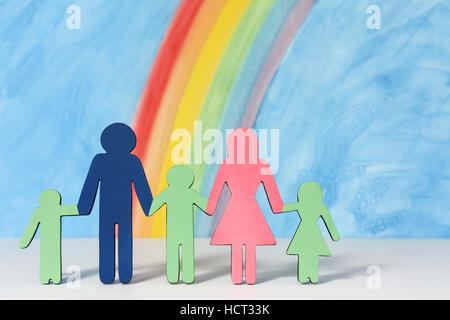 Father, mother and children icons with a rainbow and blue sky to illustrate the concept of traditional family marriage; close up Stock Photo