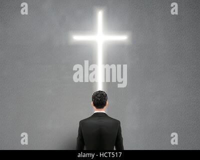 businessman stands in front of the cross light on the wall Stock Vector