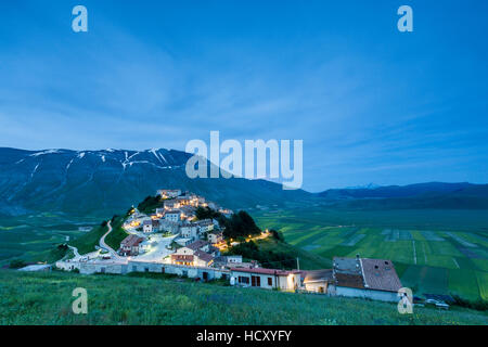Dusk on the medieval village surrounded by green fields, Castelluccio di Norcia, Province of Perugia, Umbria, Italy Stock Photo
