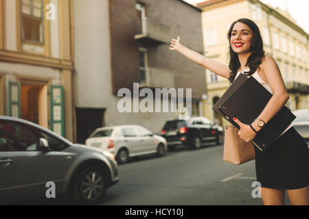 Happy businesswoman hailing cab Stock Photo