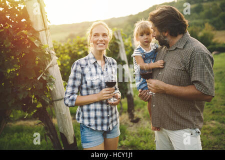 Happy wine growers tasting wine in vineyard Stock Photo