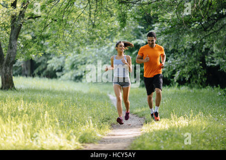 Couple jogging and running outdoors in nature Stock Photo