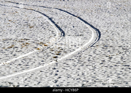 Vehicle footprints on snow-covered field
