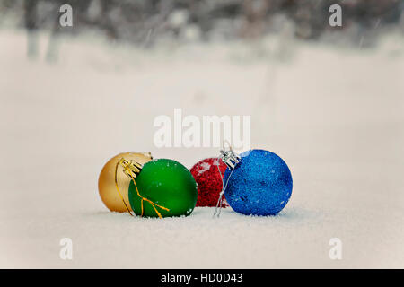 colored Christmas balls lie on the snow. Stock Photo