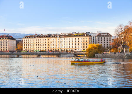 Geneva, Switzerland - November 20, 2016: Cityscape of Geneva city. Old houses stand along coast of Rhone river in autumn season Stock Photo