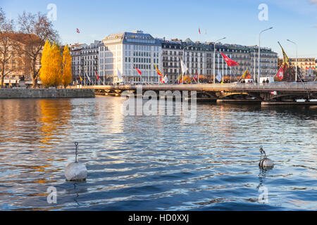 Geneva, Switzerland - November 20, 2016: Cityscape of Geneva city. Old houses stand along the coast of Rhone river near Mont Blanc bridge Stock Photo