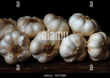 Detail of a bunch of garlic heads against a dark background Stock Photo
