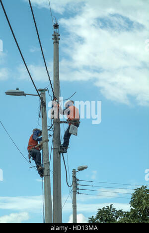 Workmen installing electrical cables on lampposts Stock Photo