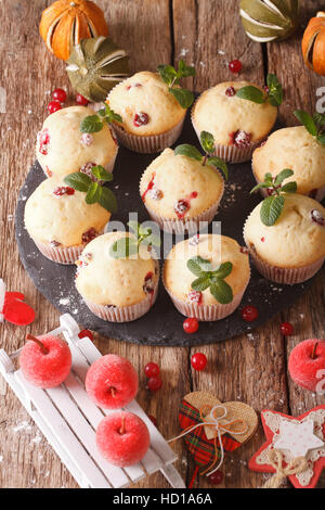 cranberry muffins with mint and Christmas decoration close-up on the table. vertical Stock Photo