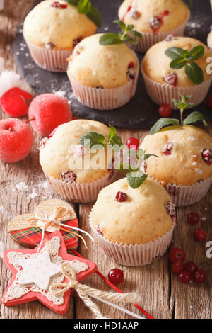 Freshly baked muffins with cranberries close-up on the table. Vertical Stock Photo