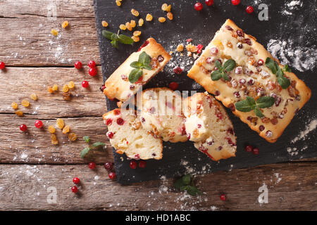 Freshly baked fruit cake with cranberries and raisins close-up on the table. horizontal view from above Stock Photo