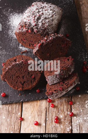 tasty chocolate cake with cranberries and chocolate close-up on the table. vertical Stock Photo