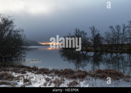 Sunrise over Malham Tarn on a very still and calm winters morning in the Yorkshire Dales, England, UK