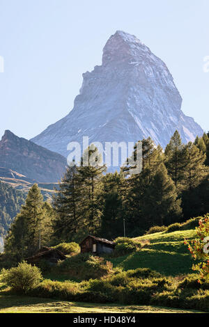 Matterhorn mountain and green valley with traditional Swiss chalet in ...
