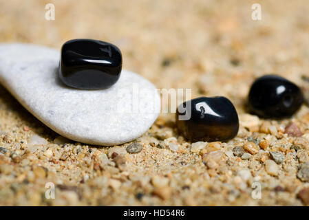 Beads and stones on the sand in natural light Stock Photo