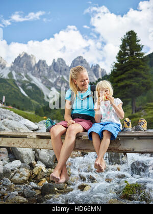 Woman, 25-30 years, blonde hair, sitting with daughter on bridge, Kemater Alm, Tyrol, Austria Stock Photo