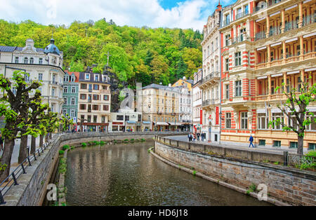 Karlovy vary, Czech republic - May 5, 2014: Luxury Grand Hotel Pupp and Promenade with Tepla River in Karlovy Vary, Czech republic. People on the back Stock Photo