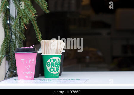 Pink tips cup and "I'm a Green cup" on a work surface Stock Photo