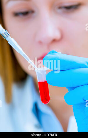 MODEL RELEASED. Woman holding micro tube and pipette, close up. Stock Photo