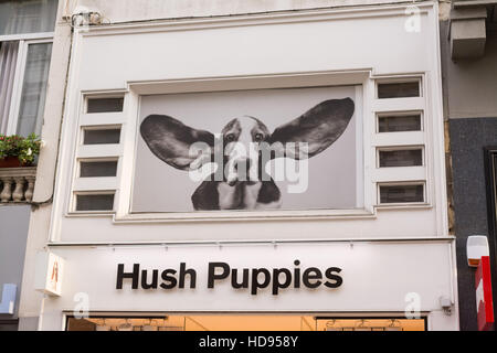 Hush Puppies sign and dog above shop Stock Photo