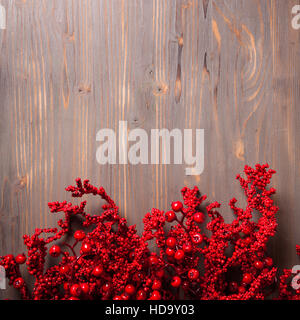 Holly berry twigs on wood wall Stock Photo