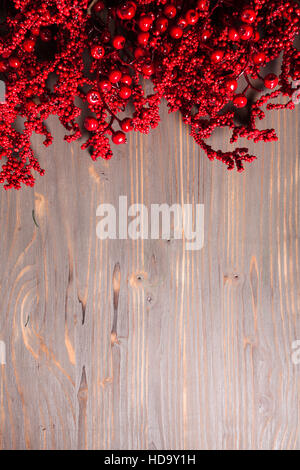 Holly berry twigs on wood wall Stock Photo