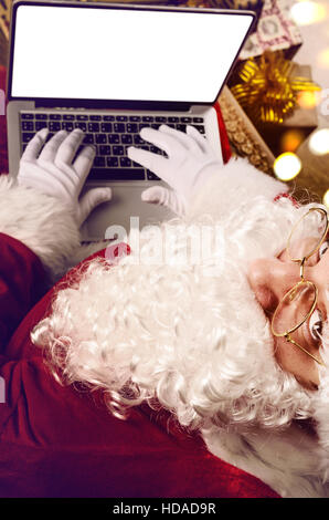 Santa Claus working on modern laptop Stock Photo