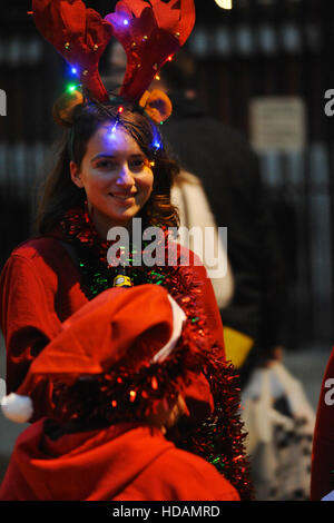 London, UK. 10th Dec, 2016. A young woman dressed as a reindeer during the annual ‘Santacon’ walk.  Described on the Facebook page as a “a non-profit, non-corporate, non-commercial and non-sensical parade of festive cheer.”, the annual walk (which is actually five routes converging on central London) is also a rather loud and raucous pub crawl, sees hundreds of revellers don Santa Claus, reindeer and elf costumes before parading through the streets toward central London where there is an after parade party. Credit:  Michael Preston/Alamy Live News Stock Photo