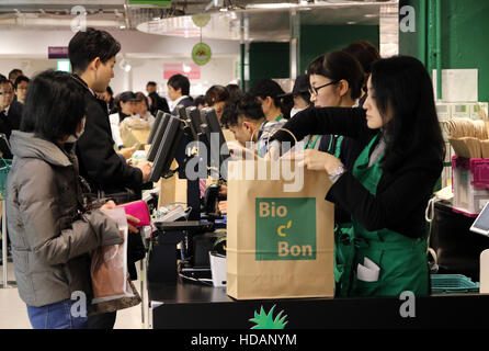 Tokyo, Japan. 9th Dec, 2016. Japananese customers pay at cashier of French organic food supermarket Bio C'Bon in Tokyo on Friday, December 9, 2016. French organic food supermarket Bio C'Bon and French frozen food maker Picard opened their shop with Japan's largest supermarket chain Aeon group. © Yoshio Tsunoda/AFLO/Alamy Live News Stock Photo