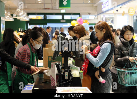 Tokyo, Japan. 9th Dec, 2016. Japananese customers pay at cashier of French organic food supermarket Bio C'Bon in Tokyo on Friday, December 9, 2016. French organic food supermarket Bio C'Bon and French frozen food maker Picard opened their shop with Japan's largest supermarket chain Aeon group. © Yoshio Tsunoda/AFLO/Alamy Live News Stock Photo