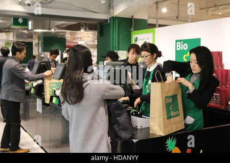 Tokyo, Japan. 9th Dec, 2016. Japananese customers pay at cashier of French organic food supermarket Bio C'Bon in Tokyo on Friday, December 9, 2016. French organic food supermarket Bio C'Bon and French frozen food maker Picard opened their shop with Japan's largest supermarket chain Aeon group. © Yoshio Tsunoda/AFLO/Alamy Live News Stock Photo