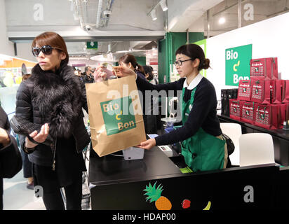 Tokyo, Japan. 9th Dec, 2016. Japananese customers pay at cashier of French organic food supermarket Bio C'Bon in Tokyo on Friday, December 9, 2016. French organic food supermarket Bio C'Bon and French frozen food maker Picard opened their shop with Japan's largest supermarket chain Aeon group. © Yoshio Tsunoda/AFLO/Alamy Live News Stock Photo