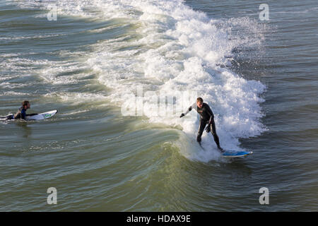 Bournemouth, Dorset, UK 11 December 2016. Surfer riding a wave, surfers enjoying the surf on a lovely sunny day at Bournemouth beach in December Credit:  Carolyn Jenkins/Alamy Live News Stock Photo