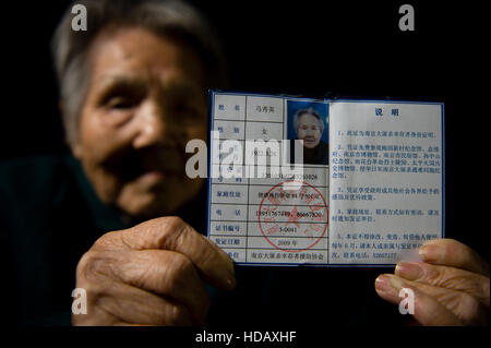 (161211) -- NANJING, Dec. 11, 2016 (Xinhua) -- Ma Xiuying demonstrates a certificate of survivors of the Nanjing Massacre, Nov. 18, 2016. Ma Xiuying, born in 1922, survived by escaping to a refugee zone with her mother during the invasion of Japanese troops in 1937.   Japanese troops occupied eastern China's Nanjing on Dec. 13, 1937, and began a six-week massacre. Chinese records show more than 300,000 people -- not only disarmed soldiers but also civilians -- were brutally murdered and thousands of women raped. In the past 79 years, the number of survivors decreases. After Zhang Fuzhi, 89, pa Stock Photo