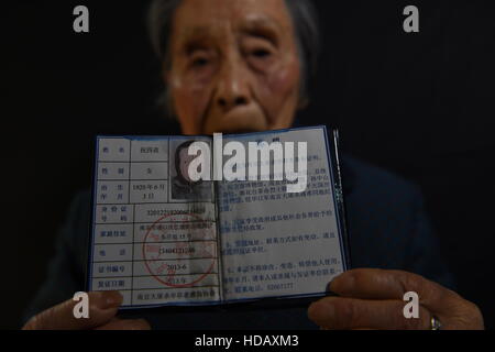 (161211) -- NANJING, Dec. 11, 2016 (Xinhua) -- Zhu Sizi demonstrates a certificate of survivors of the Nanjing Massacre, Nov. 3, 2016. Zhu Sizi, born on June 3, 1920, suffered the invasion of Japanese troops in 1937. All of her houses were burned. She and her family survived by hiding inside a burrow under a garden behind the house. Japanese troops occupied eastern China's Nanjing on Dec. 13, 1937, and began a six-week massacre. Chinese records show more than 300,000 people -- not only disarmed soldiers but also civilians -- were brutally murdered and thousands of women raped. In the past 79 Stock Photo