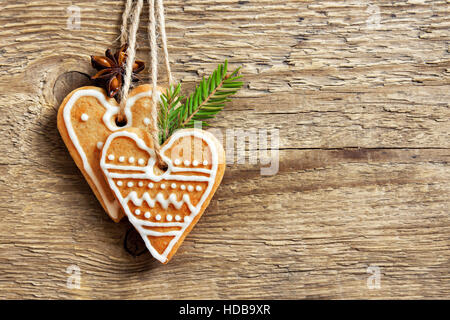 Christmas wooden background with gingerbread cookies heart shape, copy space - homemade festive decor, greeting card blank Stock Photo
