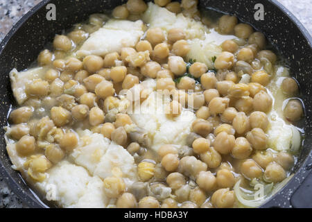 soup of salted codfish with chickpeas in pan Stock Photo