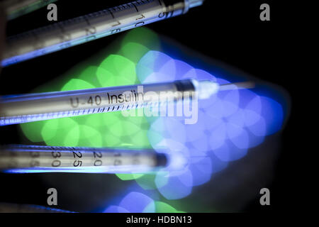 Insulin syringes on multicolored background out of focus Stock Photo