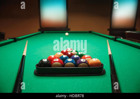 Two cues and pyramid on a billiard table. Stock Photo