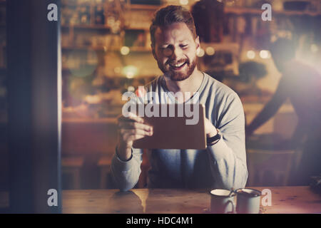 Businessman in cafe using tablet at night Stock Photo