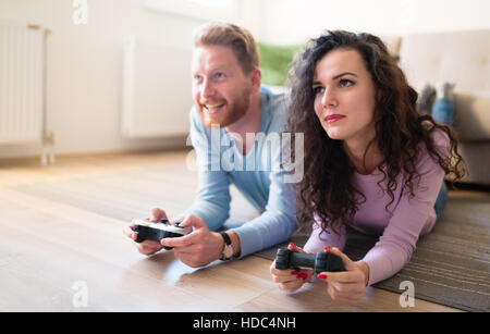 Playful friends playing video games online and having fun Stock
