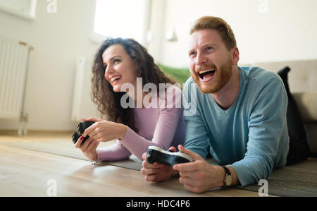 Beautiful couple playing video games on console having fun Stock Photo