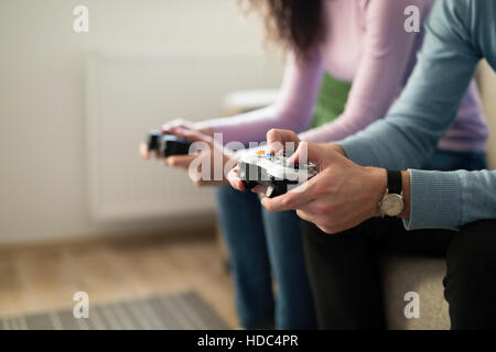 Young people playing video games on console controllers Stock Photo