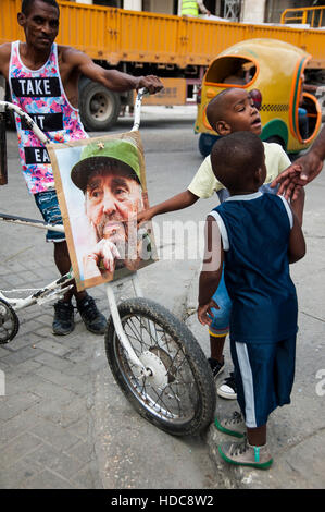 Young kids point at photo of Fidel Castro on the morning that his death was announced in Havana, Cuba Stock Photo