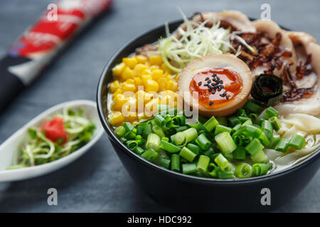 tonkotsu ramen, japanese noodle soup with pork belly, corn, spring onion and nitamago on top Stock Photo
